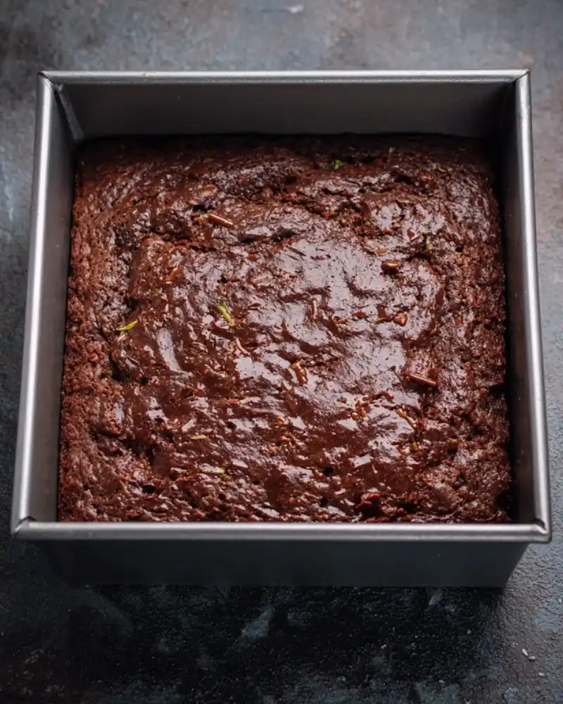 Pouring gluten free chocolate zucchini cake batter into pan