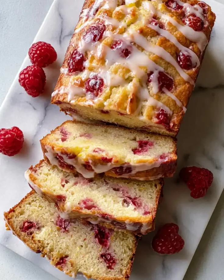 gluten free raspberry lemon loaf with glaze and raspberries