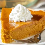 Gluten-free crustless pumpkin pie on a plate with whipped cream