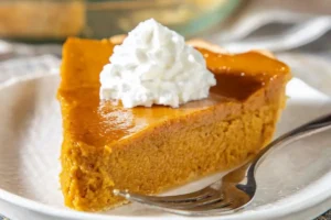 Gluten-free crustless pumpkin pie on a plate with whipped cream