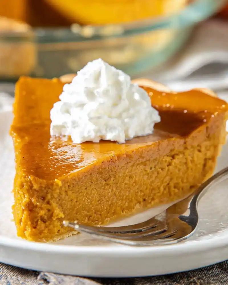 Gluten-free crustless pumpkin pie on a plate with whipped cream