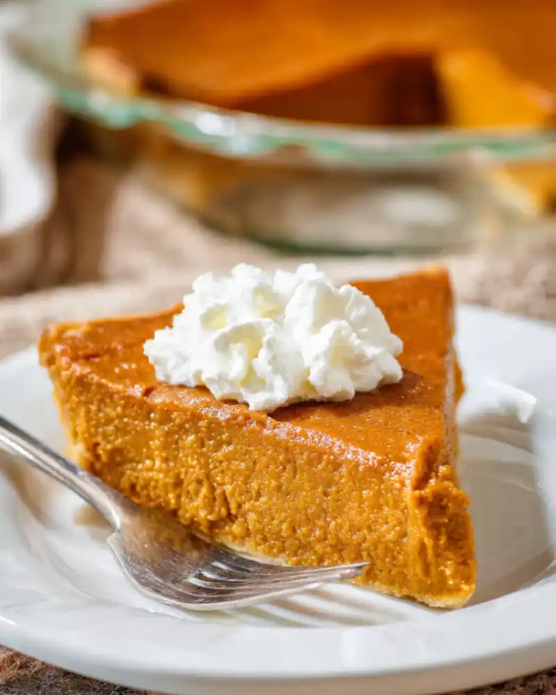 Gluten-free crustless pumpkin pie on a plate with whipped cream