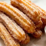 Golden crispy gluten-free churros coated in cinnamon sugar with chocolate dip