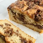 Sliced gluten-free apple fritter loaf with cinnamon apples and maple glaze