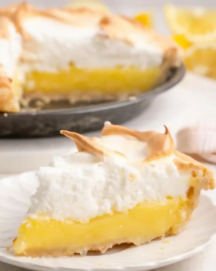Slice of gluten-free lemon meringue pie with tart lemon filling and golden meringue topping