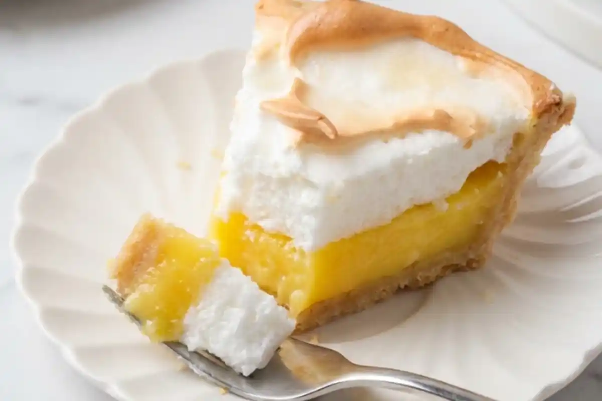 Slice of gluten-free lemon meringue pie with tart lemon filling and golden meringue topping