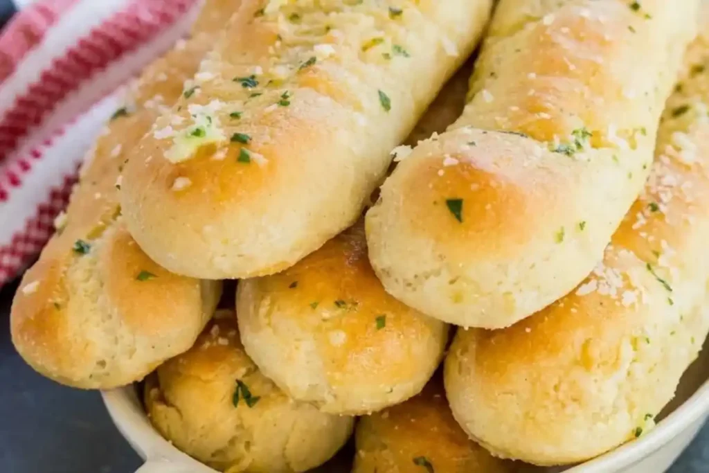 Homemade Gluten-Free Garlic Breadsticks brushed with melted garlic butter and fresh parsley.